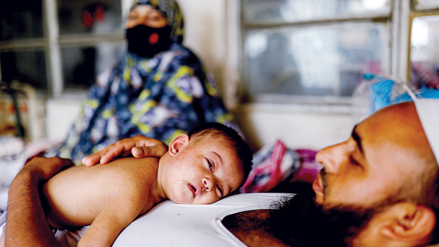 A father gently cradles his child as the little one rests on his chest while undergoing treatment with measles-like symptoms at the Infectious Diseases Hospital in Dhaka’s Mohakhali on May 23. Photo: Mehedi Hasan