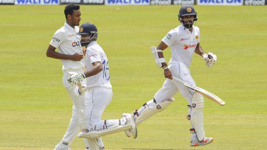 Sri Lanka's Dimuth Karunaratne (C) and Lahiru Thirimanne take a run (1) (1).jpg