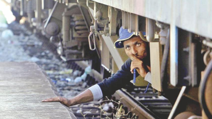 A migrant hides at a railway station in the Macedonian town of Gevgelija while waiting to climb onto a northern-bound train. Photo: AP