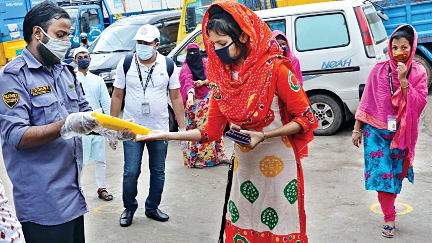 A garment worker takes hand sanitiser 