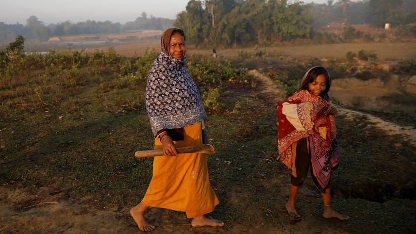 Rohingya refugee walks with her daughter