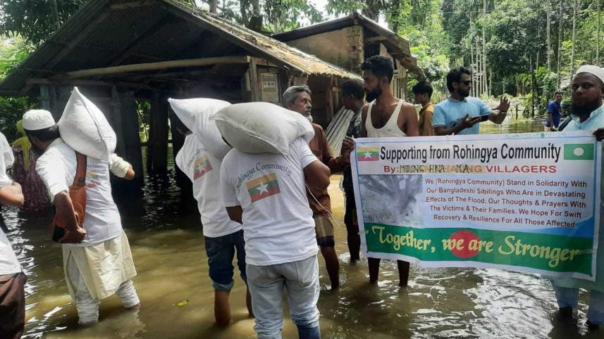 Rohingyas stand beside flood affected people.jpg