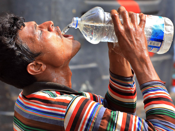 A worker drinking water in a hot summer day