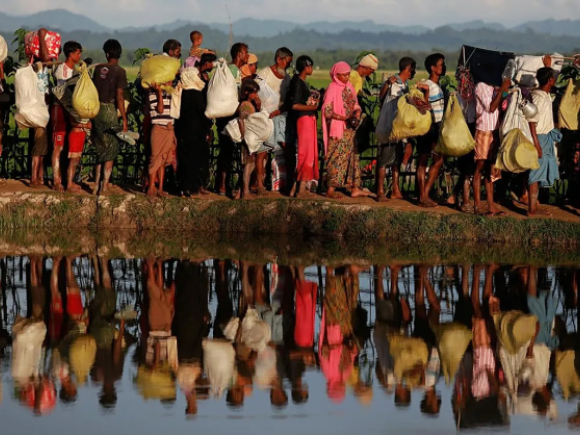 1. Rohingya refugees carry their belongings as they flee Myanmar for Bangladesh.png