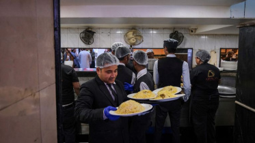 A waiter carries biryani to serve customers inside Arsalan restaurant in Kolkata, India, March 13, 2026. Photo: Reuters