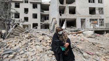 A woman sits outside her destroyed apartment after it was damaged by an airstrike while she was inside, amid the U.S.-Israeli conflict with Iran, in Tehran, Iran, March 12, 2026. Photo: Reuters