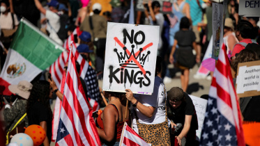A protester holds a sign reading "NO KINGS" with a crown illustration crossed out during a "No Kings" protest against U.S. President Donald Trump's policies, outside City Hall in Los Angeles, California, U.S., October 18, 2025. Photo: Reuters