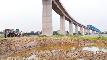 Large pits have emerged after soil was extracted from beneath the Padma rail link bridge in the Aliganj area of Narayanganj’s Fatullah. The district administration yesterday halted the excavation following locals’ concerns that the work could damage the structure. The photo was captured on June 16. Photo: Palash Khan 