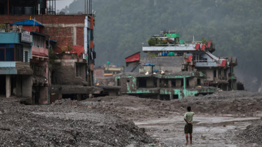 A man takes pictures in front of damaged buildings after flash floods and a mudslide, in Trishuli, Nuwakot district, Nepal, August 29, 2026. Photo: Reuters