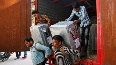 Workers unload boxes carrying Indian currency 