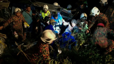 Malaysian rescuers help a survivor of a bus crash