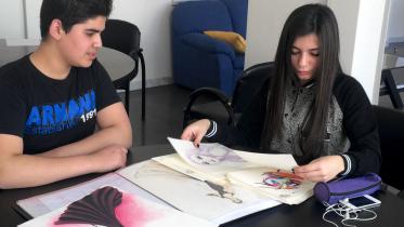 Nadeen Ghosn, a beneficiary of the Nawaya project, shows her drawings to Khaldoun, another Nawaya beneficiary, in 2014. PHOTO: THE NAWAYA PROJECT