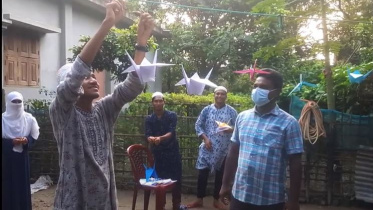 Students hanging origami pieces.JPG