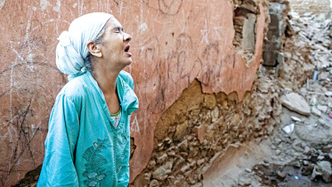 A woman standing in front of her earthquake-damaged house in the old city in Marrakesh yesterday. A powerful earthquake shook Morocco late Friday.