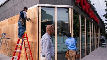 workers_cover_the_windows_of_a_pharmacy_near_the_white_house.jpg