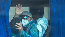 A passenger from the Dutch flagged hantavirus-stricken cruise ship MV Hondius waves aboard a military bus after being transferred by boat to the industrial port of Granadilla de Abona on the island of Tenerife in Spain's Canary Islands on May 10, 2026. Photo: AFP