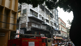 Onlookers and fire personnel gather at the site following a fire at a hotel in Kolkata on August 19, 2026. Photo: AFP