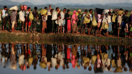 1. Rohingya refugees carry their belongings as they flee Myanmar for Bangladesh.png