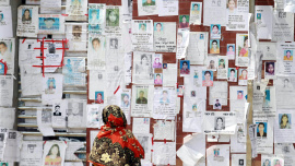 A woman looks at a wall filled with portraits of missing people on May 3, 2013 near the collapsed Rana Plaza building. PHOTO Ashraful Alam Tito Associated Press.jpg