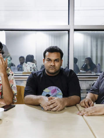 An introvert person is sitting in the middle of two extroverts